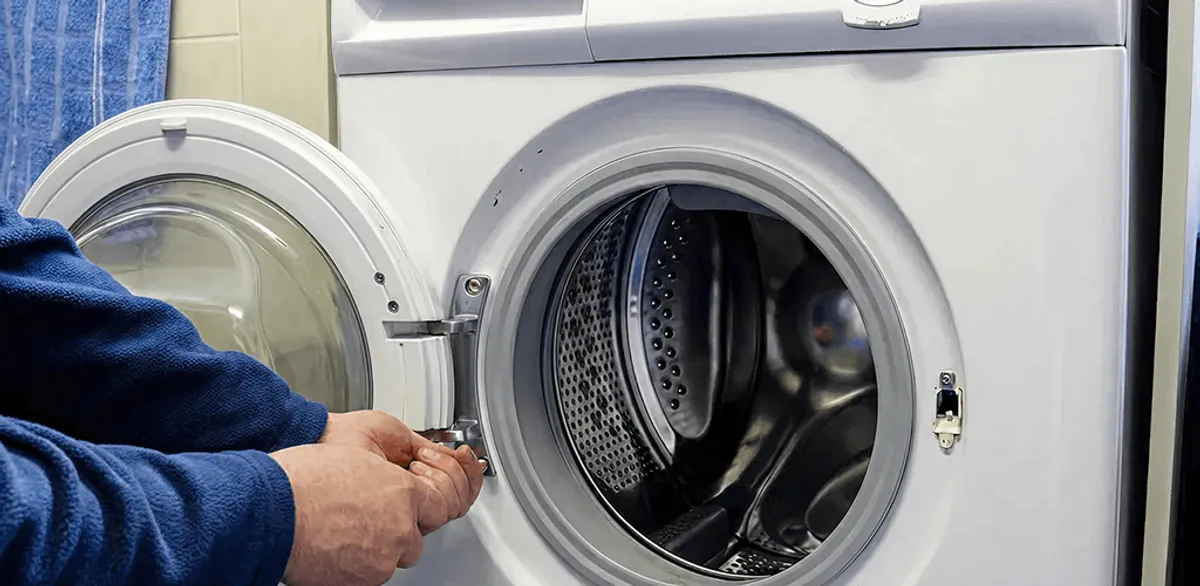 Washing machine repair handyman checking a front-load washer door and latch in Riverside, CA