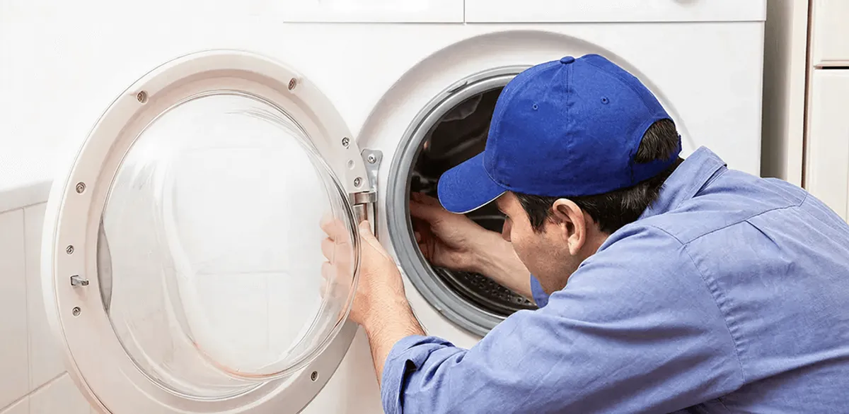 Washing machine repair handyman inspecting a front-load washer drum in Riverside, CA